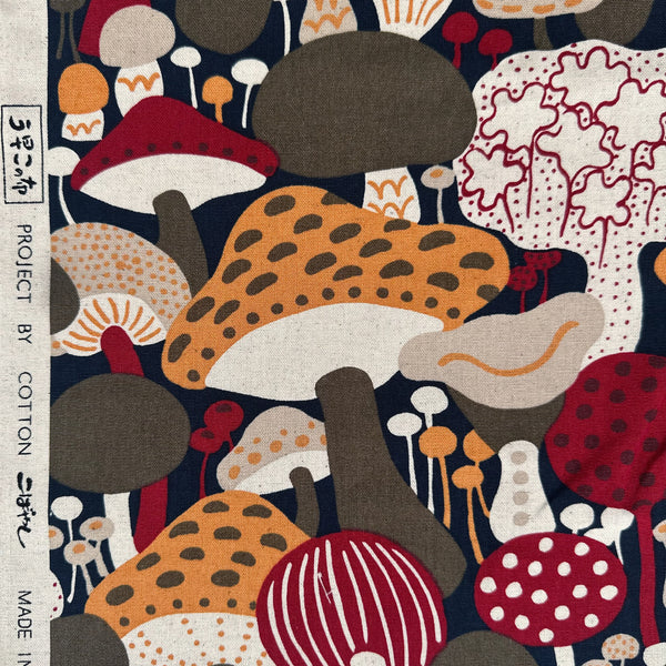 Selvage of Scandi Mushrooms Cotton Linen Canvas Fabric by Cotton Kobayashi, style UP-9014D, featuring Scandinavian mushrooms, in navy and orange, imported from Japan