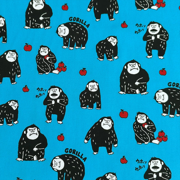 Silly Gorilla Cotton Oxford Fabric in Blue by Cosmo Textiles featuring animated gorillas and apples on a blue background.