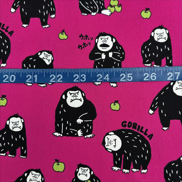 Scale of Silly Gorilla Cotton Oxford Fabric in Pink by Cosmo Textiles featuring animated gorillas and apples on a pink background.