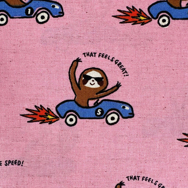 Close up of Speedy Sloth Cotton Linen Blend Fabric by Cosmo Textiles, style AP65204 2B, featuring sloths in red racing cars, in pink