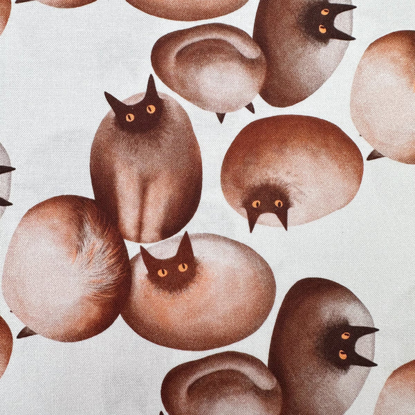 Close up of Stone Cats cotton fabric in Brown by Nora featuring round stone cats with a quirky, surreal charm and slightly eerie appeal