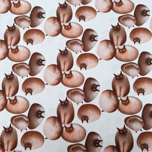 Stone Cats cotton fabric in Brown by Nora featuring round stone cats with a quirky, surreal charm and slightly eerie appeal
