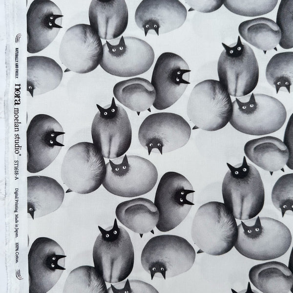 Selvage of Stone Cats cotton fabric in Gray by Nora featuring round stone cats with a quirky, surreal charm and slightly eerie appeal