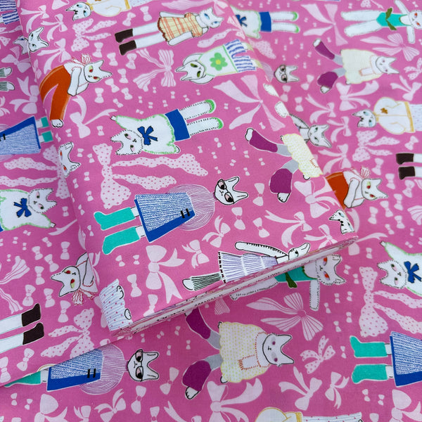 Bolt of the Open Closet cotton fabric in pink by Nora featuring cats getting dressed in cute outfits with bows imported from Japan