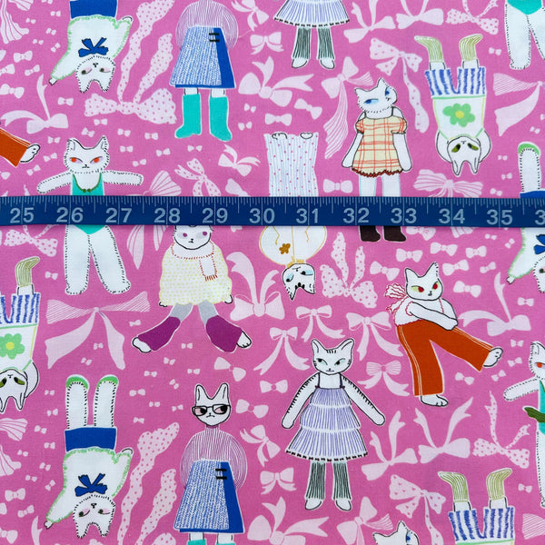 Scale of The Open Closet cotton fabric in pink by Nora featuring cats getting dressed in cute outfits with bows imported from Japan
