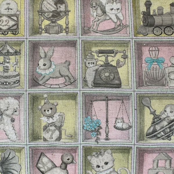 Close up of Toy Night Box cotton linen fabric by Yukiemon for Hokkoh featuring vintage-style toy illustrations arranged in boxes with soft pastel colors, imported from Japan