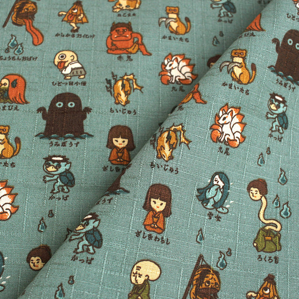 Yokai Guide Cotton Dobby Fabric by Cosmo Textiles, style AP62206 2B, featuring Japanese folklore spirits and monsters, in dusty jade, imported from Japan